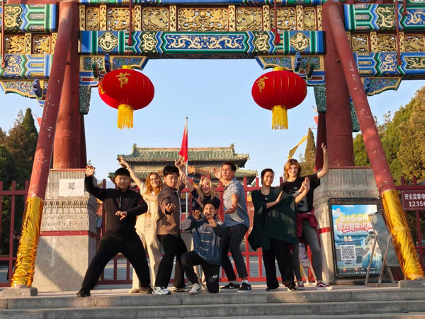 International students at a Chinese temple gate with red lanterns, Henan Province