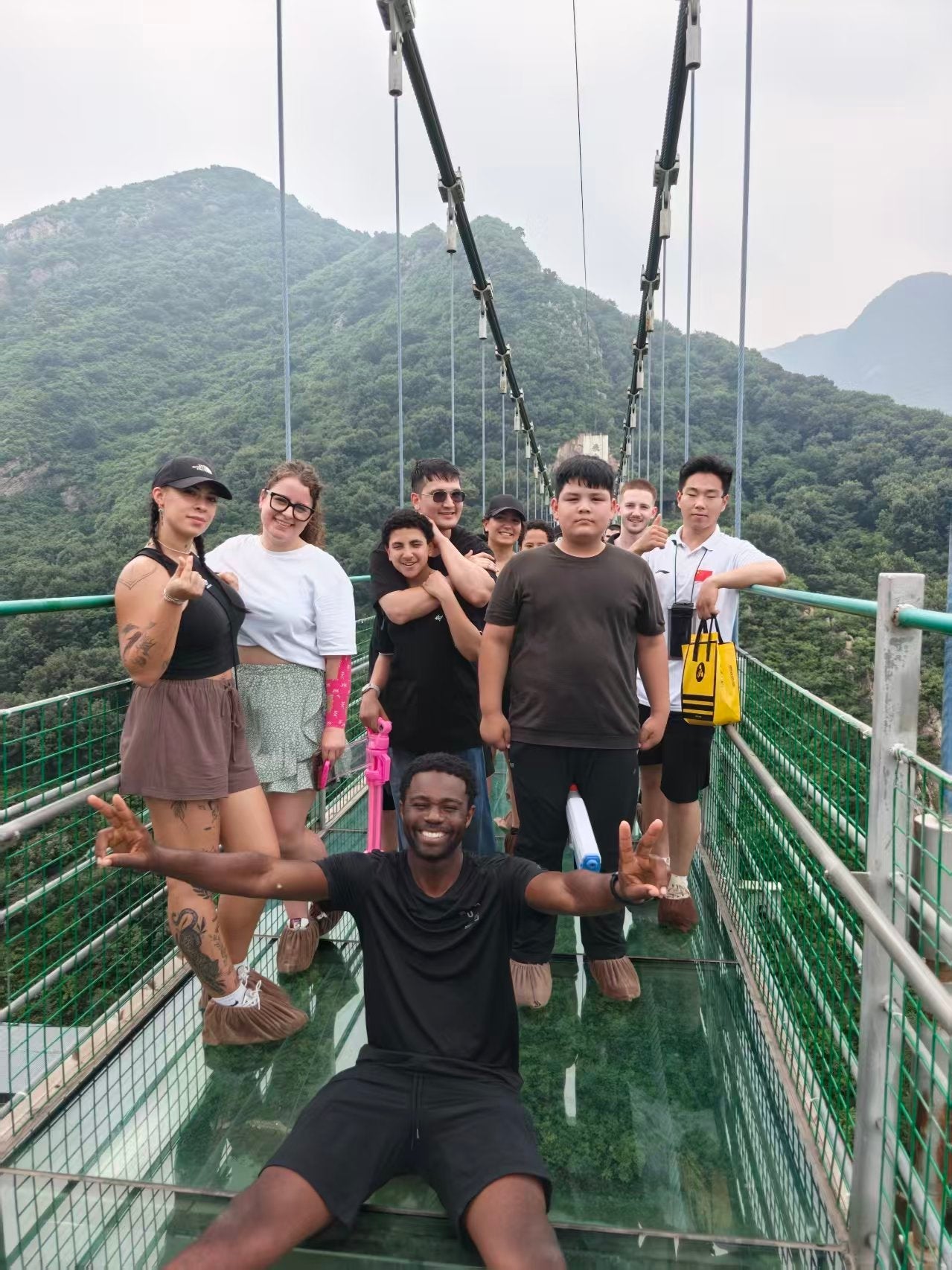 Students on the glass suspension bridge over Mount Song near the Songshan Shaolin Temple scenic area