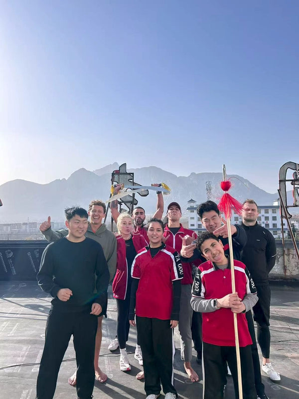 Students training Shaolin weapons on a rooftop with Mount Song behind, Dengfeng China